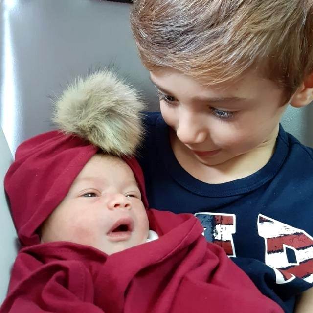 Daniel conhecendo a irmã Olivia recém-nascida na maternidade